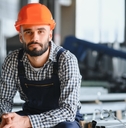 worker wearing uniform and hard hat in a steel factory