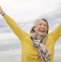 happy senior woman holding hands in air outdoor