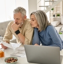 senior couple sitting on table reviewing documents