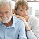 senior couple thinking while sitting on couch