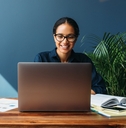 smiling entrepreneur sitting at home working on laptop