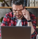 businessman in eyewear looking at computer screen