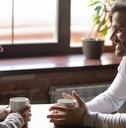 couple sitting in cafe talking drinking tea or coffee