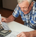 senior man sitting at the table and calculating finances
