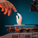 A human hand touching a 3D-printed hand