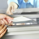 A woman is handing a check to cash it out