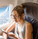 woman sitting with phone on the aircraft seat