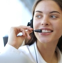 beautiful woman at workplace talking to customer on headset