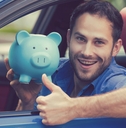 Man holding a piggy bank while riding a car