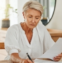 senior woman with notebook writing budget plan