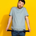 young man standing in front of yellow background showing empty pockets