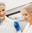 women technologists with clipboard tasting ice cream