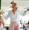 female boss angry at employees holding papers in hands at work