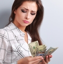unhappy woman looking on dollars and thinking