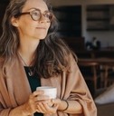 thoughtful senior woman holding a tea cup at home