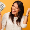 woman wearing white sweater screaming in excitement while holding money in hand in front of orange background