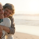 couple having each other back while smiling at beach