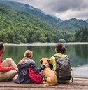 family having a vacation with their dog at mountainous area resting on pier together