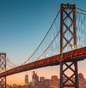 oakland bridge on water surrounding san francisco skyscrapers
