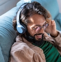 young man wearing headphones listens to mobile music