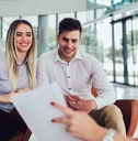 financial advisor showing report to young couple