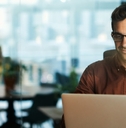 businessman wearing glasses using laptop at work
