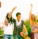 hippie friends standing on road in countryside holding drums and instruments