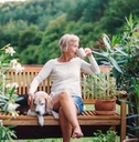 senior woman sitting on bench at terrace enjoying coffee