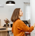 young woman controlling home with a digital touch screen panel