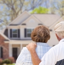 senior couple sitting at front house after retirement