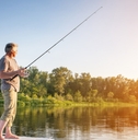 senior man standing on boat fishing