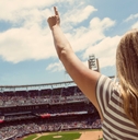 woman standing and cheering at a baseball game