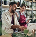 shop assistants with laptop working in potted plant store