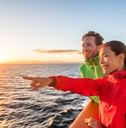 cruise travel tourists couple pointing at sea view from ferry tour
