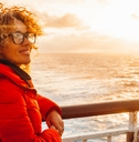 young adult woman enjoying sunset  on a ferry cruise