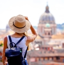 female tourist wearing black backpack and sunny hat exploring rome while on vacation