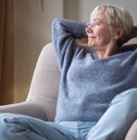senior woman resting seated on coach