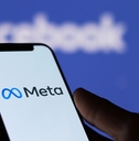 man holding smartphone with meta logo