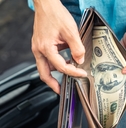 woman hands holding a wallet with dollar currency
