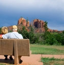 senior couple enjoying vacation while sitting on bench in arizona during day time