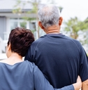 senior couple from behind looking at front of house
