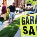 garage sale sign in front of house with shoppers in background