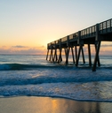 vero beach pier at sunset with water at shore