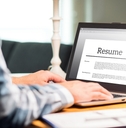 man writing resume and cv in home office with laptop