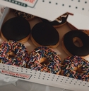 Close up of Krispy Kreme donuts with chocolate glaze and colorful sprinkles.