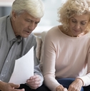 A retired married couple looking at a budget