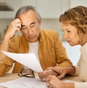 senior spouses sitting at table full of papers
