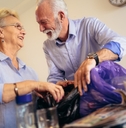 smiling senior couple recycling trash