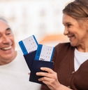 senior tourists holding boarding passes