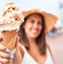 woman showcases delicious ice cream cone.